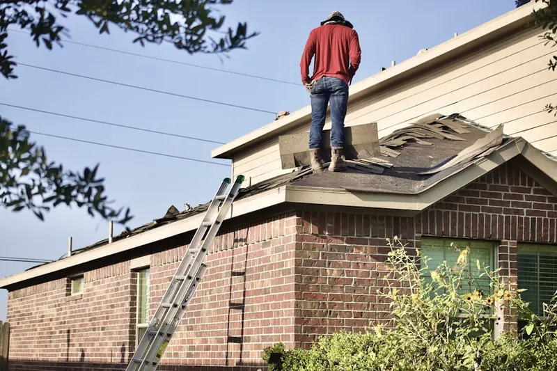 Professional roofer working on a residential roof in Kratz